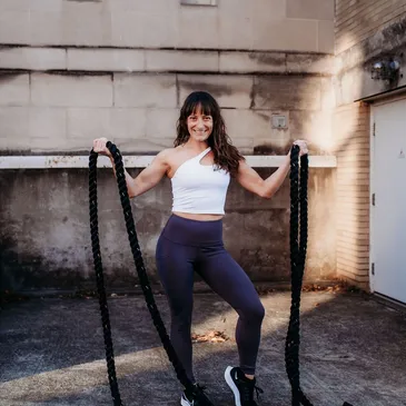 A woman is holding some ropes in her hands