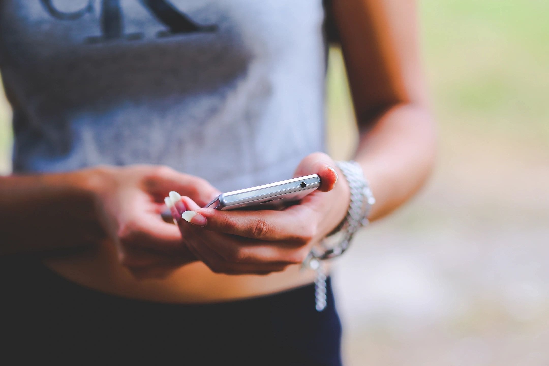 A person holding a cell phone in their hands.